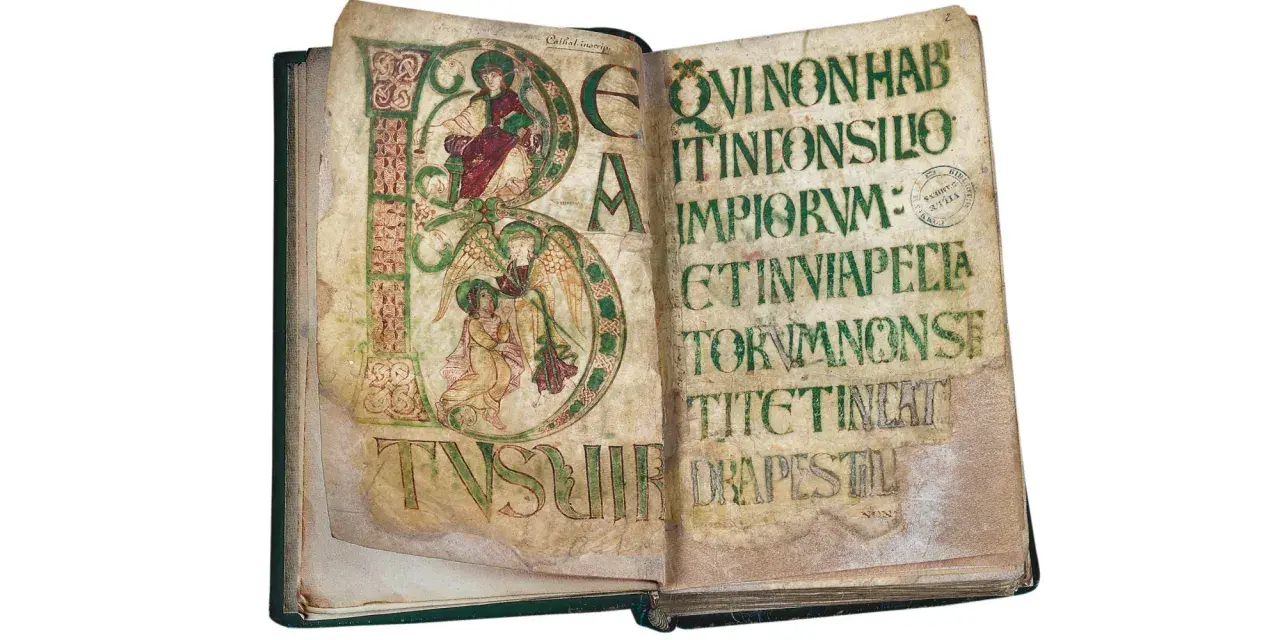 Manuscrit carolingien ouvert, pages ornées de lettres capitales enluminées et de texte en latin. L'une des pages présente une scène avec des anges.